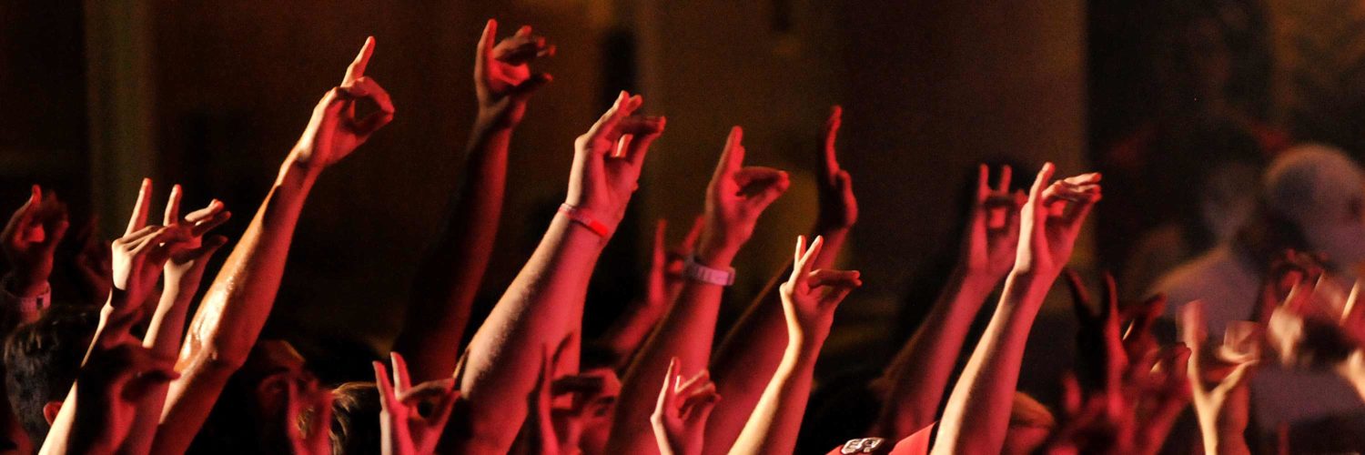 A sea of hands showing the Wolfpack gesture