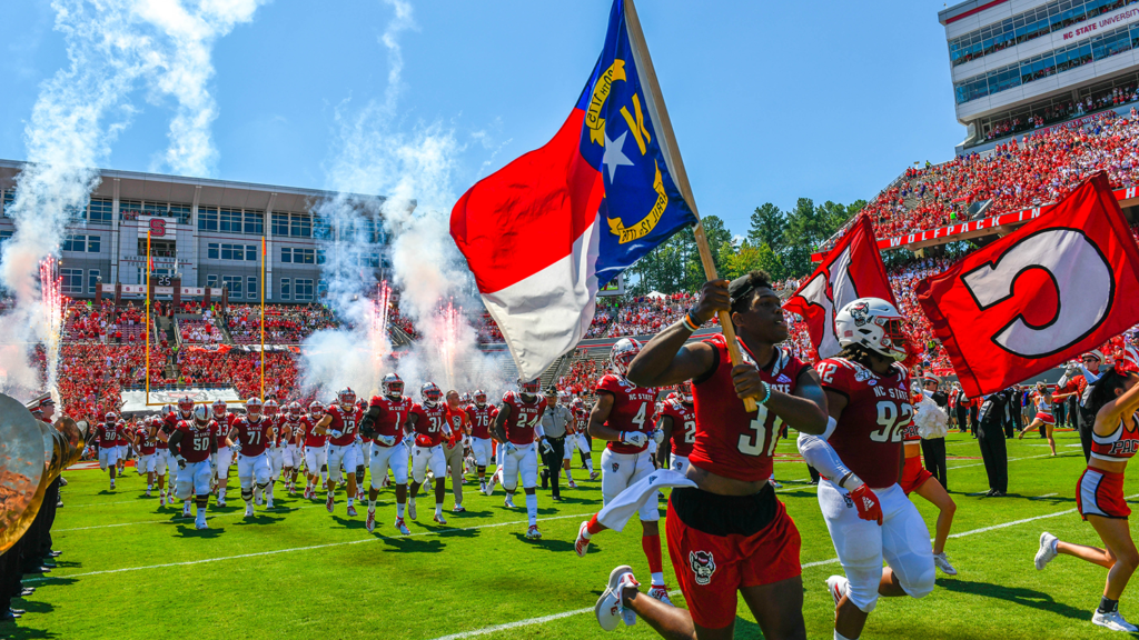 Football players enter the field at Carter-Finley Stadium.