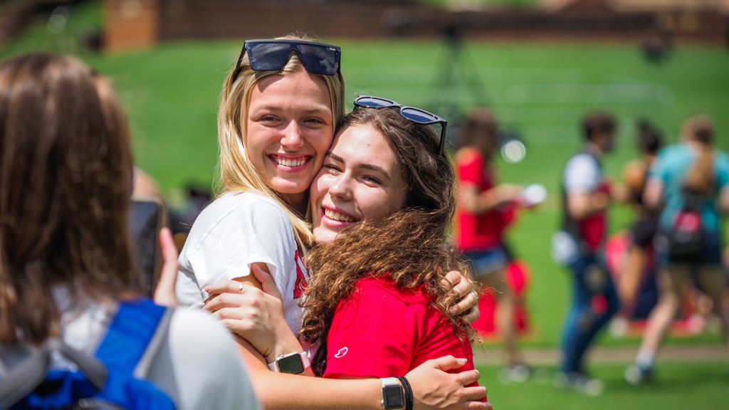 Two women embrace on campus.