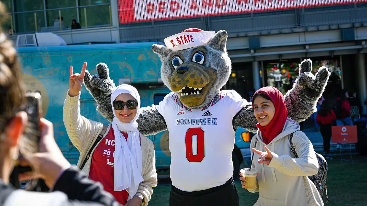 Students pose with Mr. Wuf on Stafford Commons during Red and White Week.